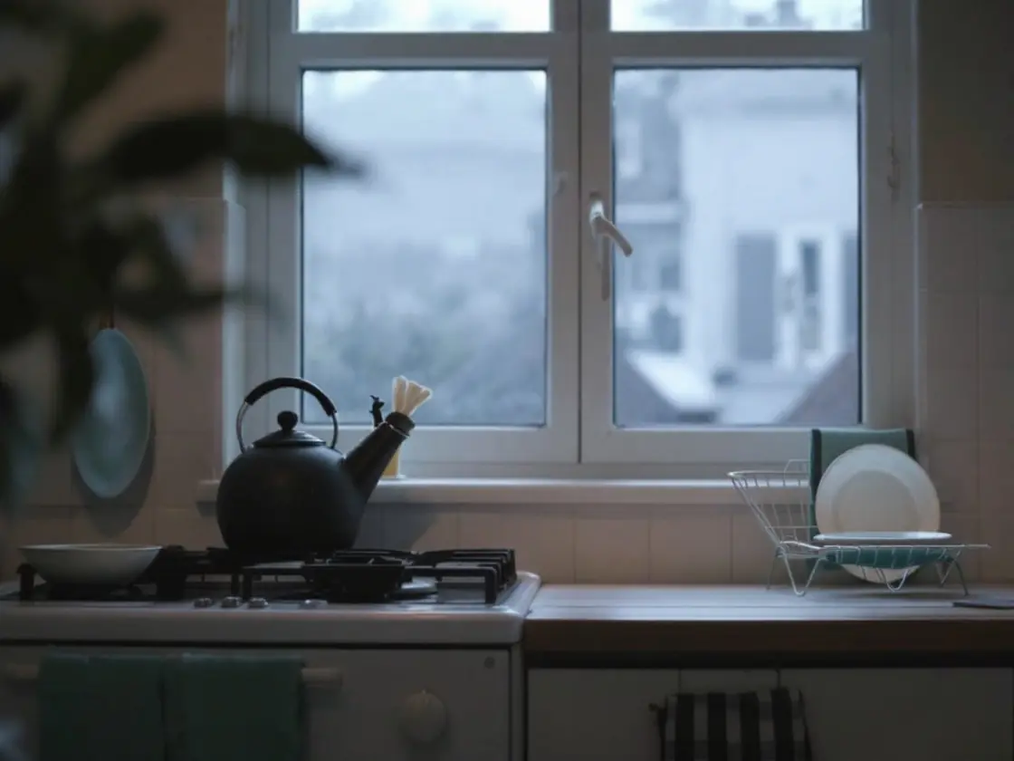 A small kitchen at dawn with a kettle on the stove
