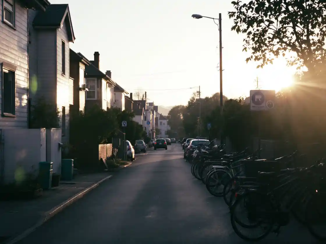 A quiet residential street at sunrise with parked bicycles