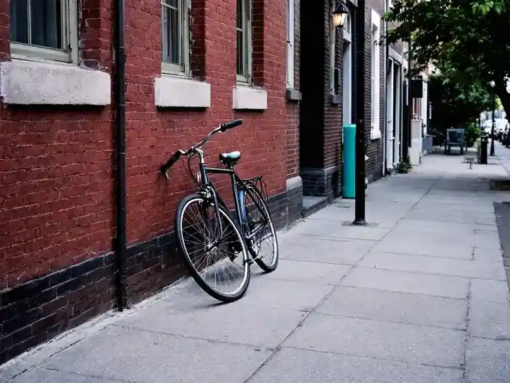 A bicycle leaning against a brick wall on a quiet street