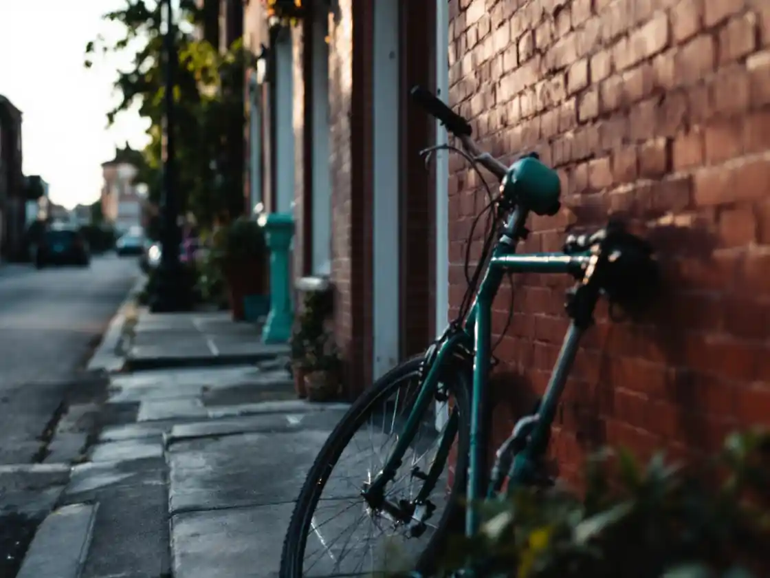A bicycle leaning against a brick wall on a quiet street